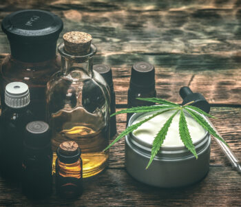 Cannabis face cream or moisturizer jar and cbd oil bottles concept.